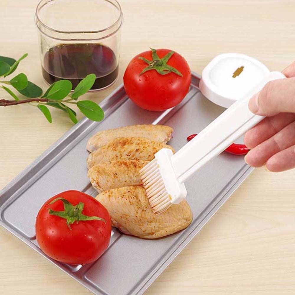 Brushing oil on grilled chicken